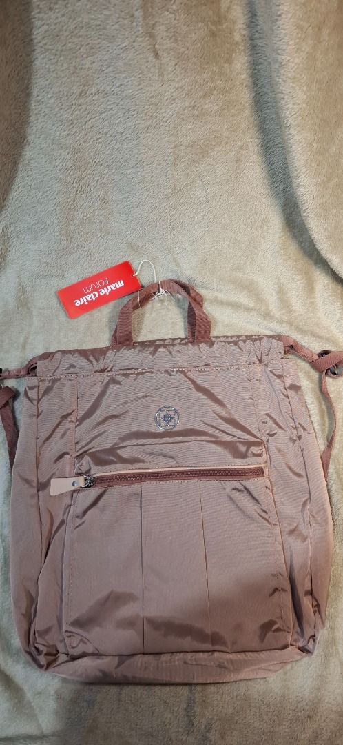 Lux Draw string/ backpack (Category: Luxury Bags & Wallets) located in General Santos City (Dadiangas). Submitted by sloane.sloane (Listing ID 1459370740, Image 3). Description: Brown nylon convertible tote backpack featuring a front vertical zipper pocket and a branded label reading "marie claire Forum"..