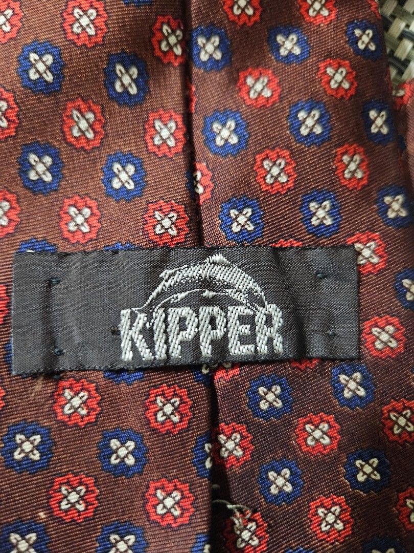Macy's California Kipper Silk Tie - Red Blue Pattern (Category: Ties) located in Rizal. Submitted by cherry_garcia (Listing ID 1459382265, Image 2). Description: - Classic silk tie from Macy's California - Rich brown background with a repeating red and blue floral-like pattern - Small Kipper brand tag on the back - Ideal for formal events or business casual attire - Adds a stylish pop of color to your look.