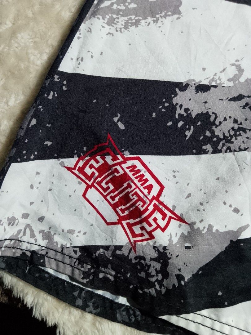 MMA Elite Board Shorts Samurai Design (Category: Shorts) located in Bantayan. Submitted by markjimenez1975557 (Listing ID 1459413075, Image 3). Description: excellent small on tag waist 29-31 length 22 with single ran - Cool MMA Elite board shorts - Features a samurai warrior graphic on one side - Black and white stripe pattern on the other side - Drawstring waist for a secure fit - Ideal for swimming or training sessions.