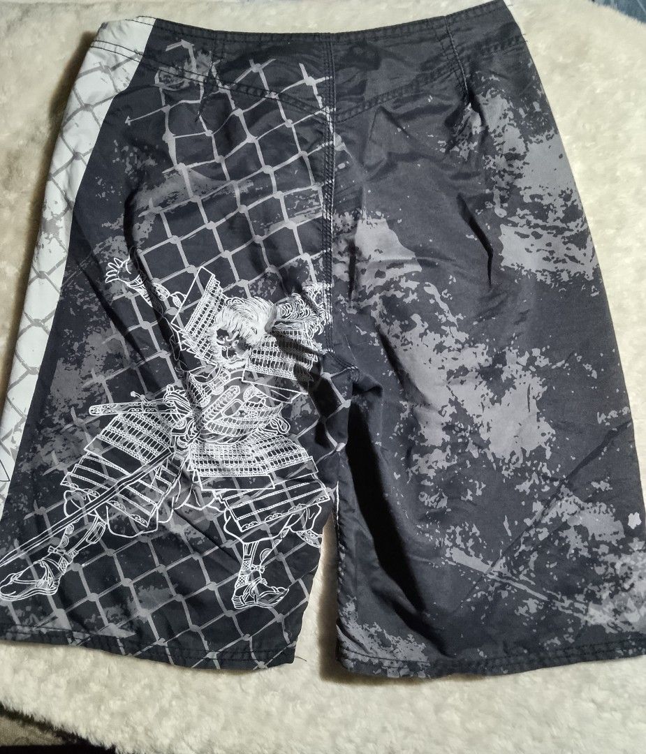 MMA Elite Board Shorts Samurai Design (Category: Shorts) located in Bantayan. Submitted by markjimenez1975557 (Listing ID 1459413075, Image 2). Description: excellent small on tag waist 29-31 length 22 with single ran - Cool MMA Elite board shorts - Features a samurai warrior graphic on one side - Black and white stripe pattern on the other side - Drawstring waist for a secure fit - Ideal for swimming or training sessions.