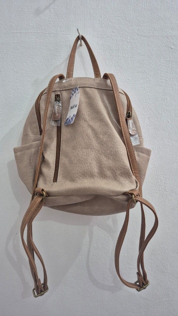 Multi Sac Beige Faux Leather Mini Backpack (Category: Backpacks) located in Mandaluyong City. Submitted by sdl_ftn (Listing ID 1459349134, Image 3). Description: - Cute beige mini backpack from Multi Sac - Faux leather material with brown trim - Main zippered compartment - Front zippered pocket - Adjustable straps - Perfect for everyday use or travel - Still has tags attached - can fit 178 x 254 MM Green Apple Notebook.