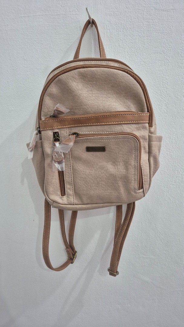 Multi Sac Beige Faux Leather Mini Backpack (Category: Backpacks) located in Mandaluyong City. Submitted by sdl_ftn (Listing ID 1459349134, Image 2). Description: - Cute beige mini backpack from Multi Sac - Faux leather material with brown trim - Main zippered compartment - Front zippered pocket - Adjustable straps - Perfect for everyday use or travel - Still has tags attached - can fit 178 x 254 MM Green Apple Notebook.