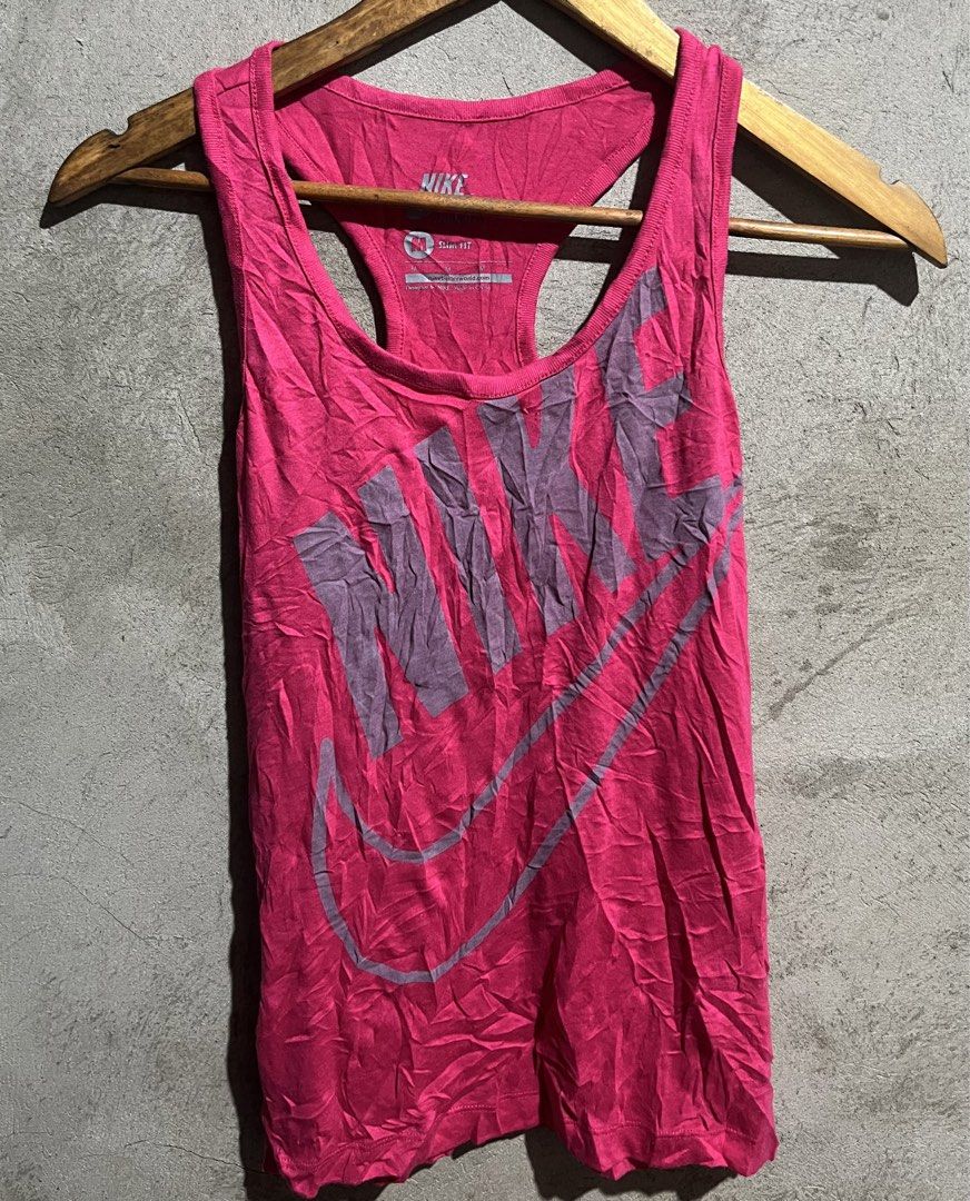Nike Pink Racerback Tank Top (Category: Sleeveless) located in Manila. Submitted by jian_thrift (Listing ID 1459443285, Image 1). Description: - Bright pink Nike tank top - Racerback style - Large grey Nike logo graphic on front - Slim fit - Ideal for workouts or casual wear - Soft and breathable material - Pairs well with leggings or shorts.