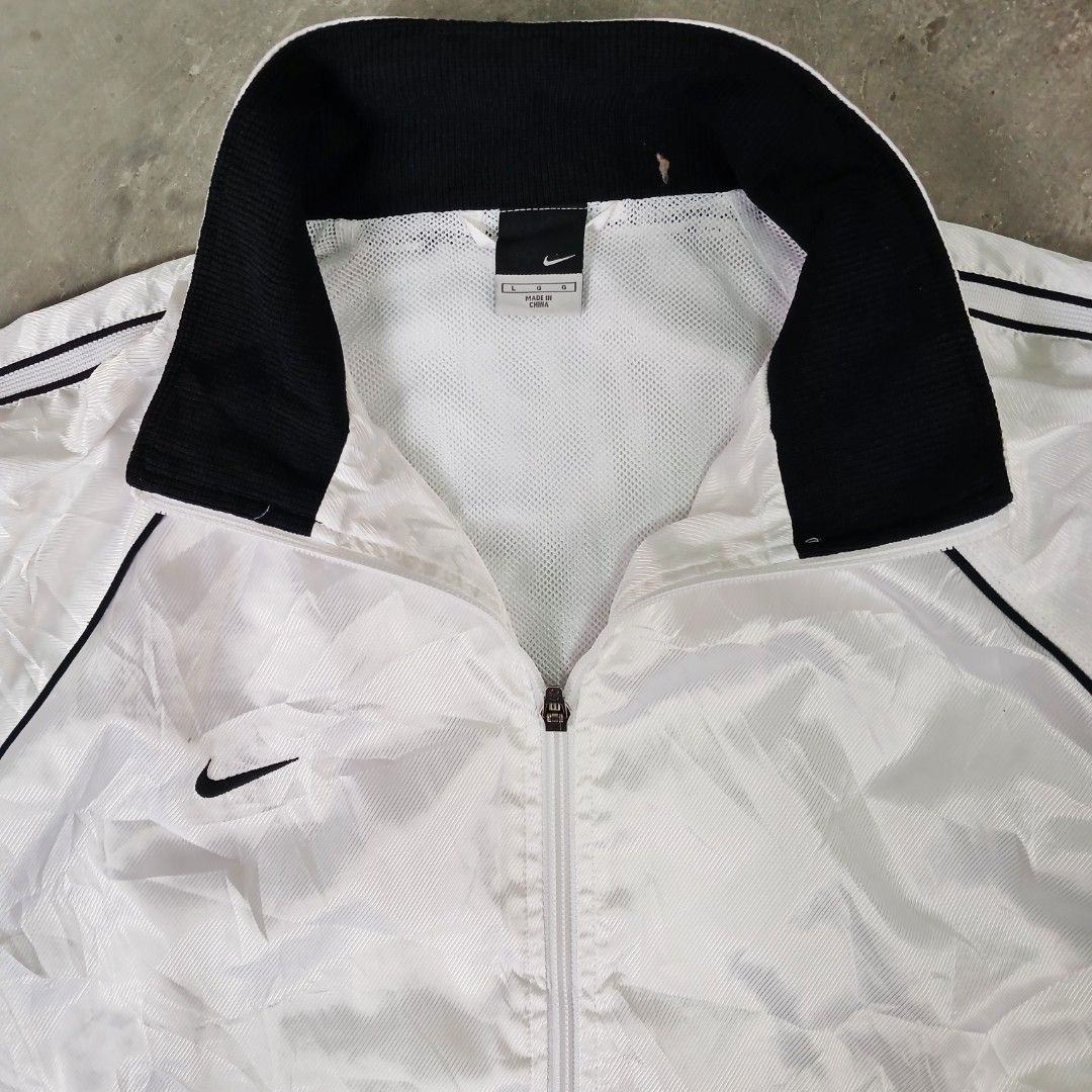 Nike White Track Jacket (Category: Coats, Jackets and Outerwear) located in Manila. Submitted by joefrey12 (Listing ID 1459373062, Image 3). Description: - White Nike track jacket - Large 23x27 - Black piping on sleeves and collar - Full zip closure - Mesh lining inside - Size: Large (L) - Ideal for casual wear or sports activities.