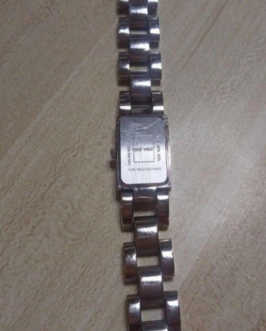Nine West Women's Watch (Category: Women's Watches) located in Pasig City. Submitted by carlosaini41 (Listing ID 1459324601, Image 3). Description: - Brand: Nine West - Band: Silver and gold tone metal - Band Condition: Minor scratches - Face: Rectangular - Dial Color: Champagne - Dial Features: Shows numbers 12 and 6 - Condition: Functional, sold as is -Size: 16 to 17 cm .