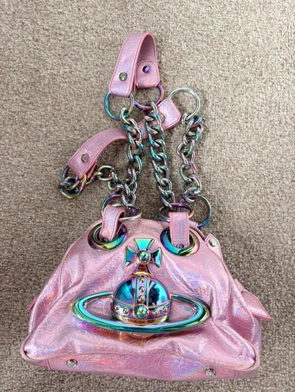 VivienneWestwood (Category: Shoulder Bags) located in Baler. Submitted by gemsandrare (Listing ID 1459484872, Image 1). Description: - Cute pink iridescent handbag - Shiny, crackled texture - Rainbow colored chain straps and hardware - Zipper closure at the top - Small flap pocket on the front - Fun accessory for any outfit.