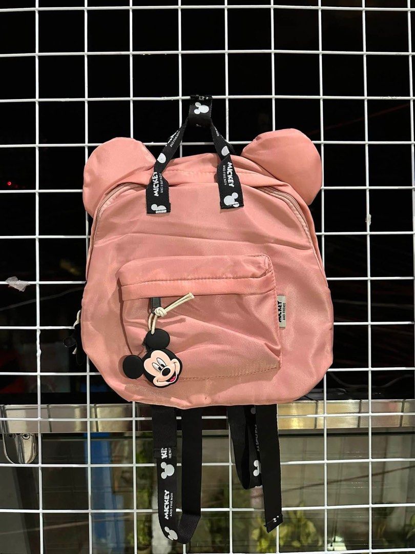 Pink Mickey Mouse Ears Backpack with Charm (Category: Backpacks) located in Santa Rosa. Submitted by yasss23 (Listing ID 1459305671, Image 1). Description: - Adorable pink backpack featuring iconic Mickey Mouse ears. - Comes with a cute Mickey Mouse charm on the front pocket zipper. - Straps are printed with a fun Mickey Mouse design. - Offers plenty of space inside for all your essentials. - Perfect for everyday use, school, or travel adventures