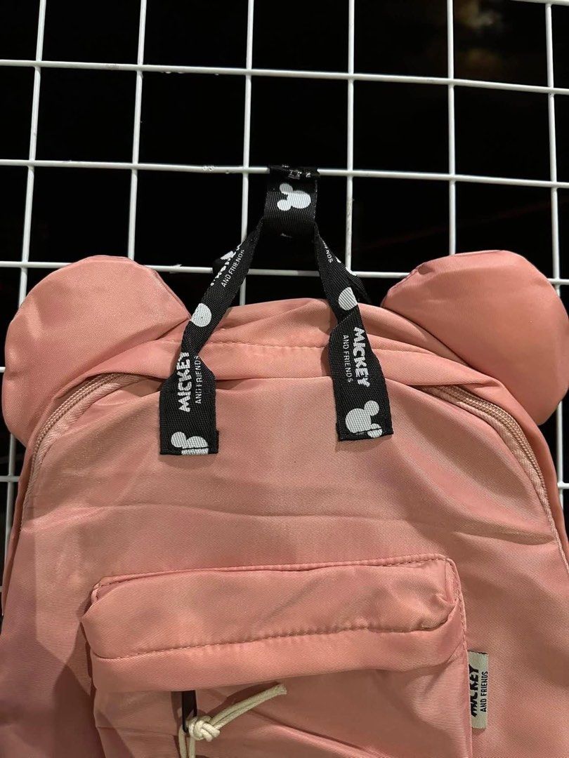 Pink Mickey Mouse Ears Backpack with Charm (Category: Backpacks) located in Santa Rosa. Submitted by yasss23 (Listing ID 1459305671, Image 3). Description: - Adorable pink backpack featuring iconic Mickey Mouse ears. - Comes with a cute Mickey Mouse charm on the front pocket zipper. - Straps are printed with a fun Mickey Mouse design. - Offers plenty of space inside for all your essentials. - Perfect for everyday use, school, or travel adventures
