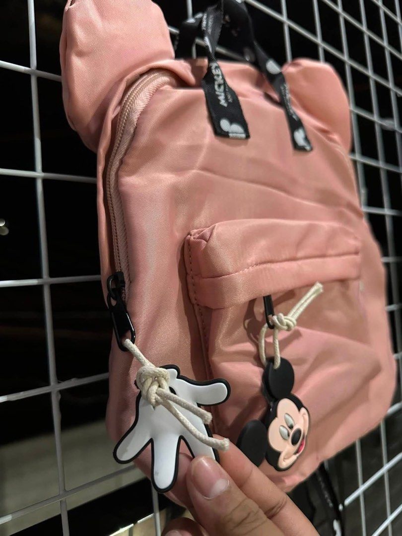 Pink Mickey Mouse Ears Backpack with Charm (Category: Backpacks) located in Santa Rosa. Submitted by yasss23 (Listing ID 1459305671, Image 2). Description: - Adorable pink backpack featuring iconic Mickey Mouse ears. - Comes with a cute Mickey Mouse charm on the front pocket zipper. - Straps are printed with a fun Mickey Mouse design. - Offers plenty of space inside for all your essentials. - Perfect for everyday use, school, or travel adventures
