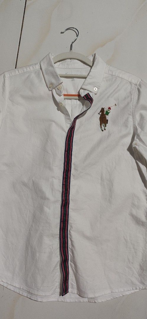 Polo Sport White Button Down Shirt Size 12 (Category: Tshirts & Polo Shirts ) located in Villasis. Submitted by znivvfinds (Listing ID 1459421017, Image 2). Description: - Brand: Polo Sport - Color: White - Style: Long-sleeved button-down shirt - Features: Classic polo player embroidery on chest, striped trim detail on front placket - Size: 12 - Occasion: Great for casual or smart-casual wear.