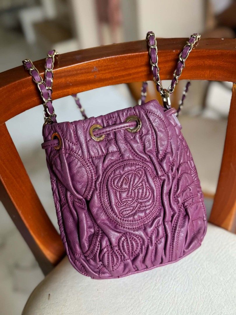 Purple Leather Drawstring Bucket Bag with Chain Strap (Category: Cross-body Bags) located in Bacolod City. Submitted by vintage_vogue6100 (Listing ID 1459414013, Image 1). Description: - Stylish purple leather drawstring bucket bag - Features a chic quilted pattern - Embossed logo detail for a touch of luxury - Elegant gold chain strap with comfortable leather accents - Secure drawstring closure with a snap button flap - Versatile design, ideal f