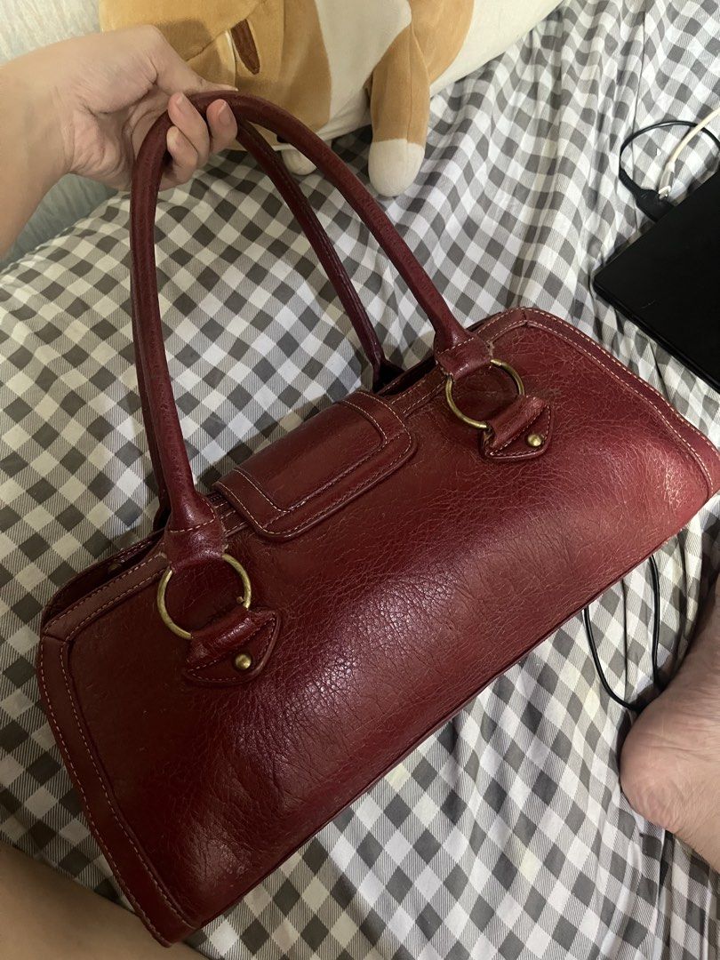 Red Leather Shoulder Bag with Gold Hardware (Category: Luxury Bags & Wallets) located in Manila. Submitted by declutbyal (Listing ID 1459321063, Image 2). Description: - Classic red leather shoulder bag - Gold-toned hardware and stud details - Main zippered compartment - Exterior pocket with snap closure - Textured leather finish - Ideal for everyday use.