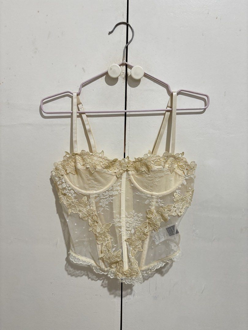 SHEIN Cream Lace Corset Top (Category: Sleeveless) located in Manila. Submitted by dianafayesimbre (Listing ID 1459361313, Image 1). Description: - Sheer lace corset top - Features delicate floral appliques - Adjustable straps for a perfect fit - Front hook-and-eye closure for easy wear - Scalloped lace trim along hem and neckline - Cute dotted pattern on sheer fabric - Versatile for layering or wearing solo - Size XS on tag but can fit up to sem