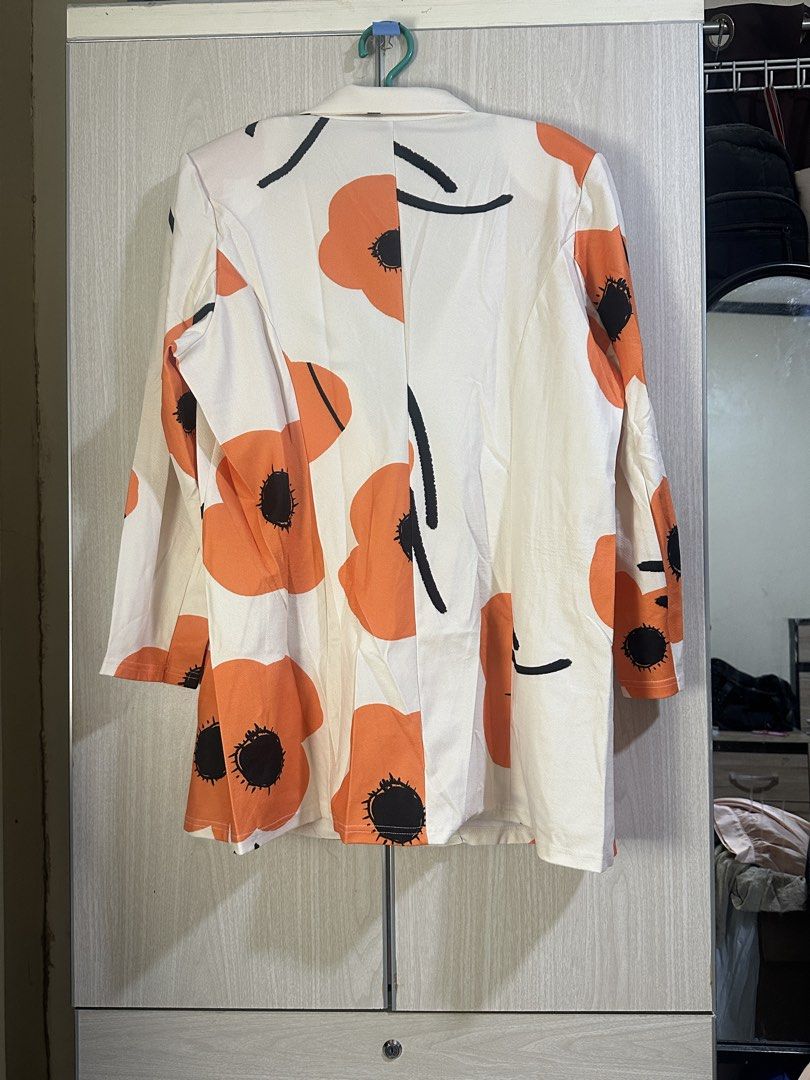 SHEIN Floral Print Blazer (Category: Coats, Jackets and Outerwear) located in Taguig. Submitted by ibsss (Listing ID 1459446838, Image 2). Description: - White blazer with a striking orange floral print. - Features black accent details. - Single button closure at the front. - Long sleeves. - Versatile piece: dress up jeans or trousers. - Ideal for adding a stylish touch to your outfit..