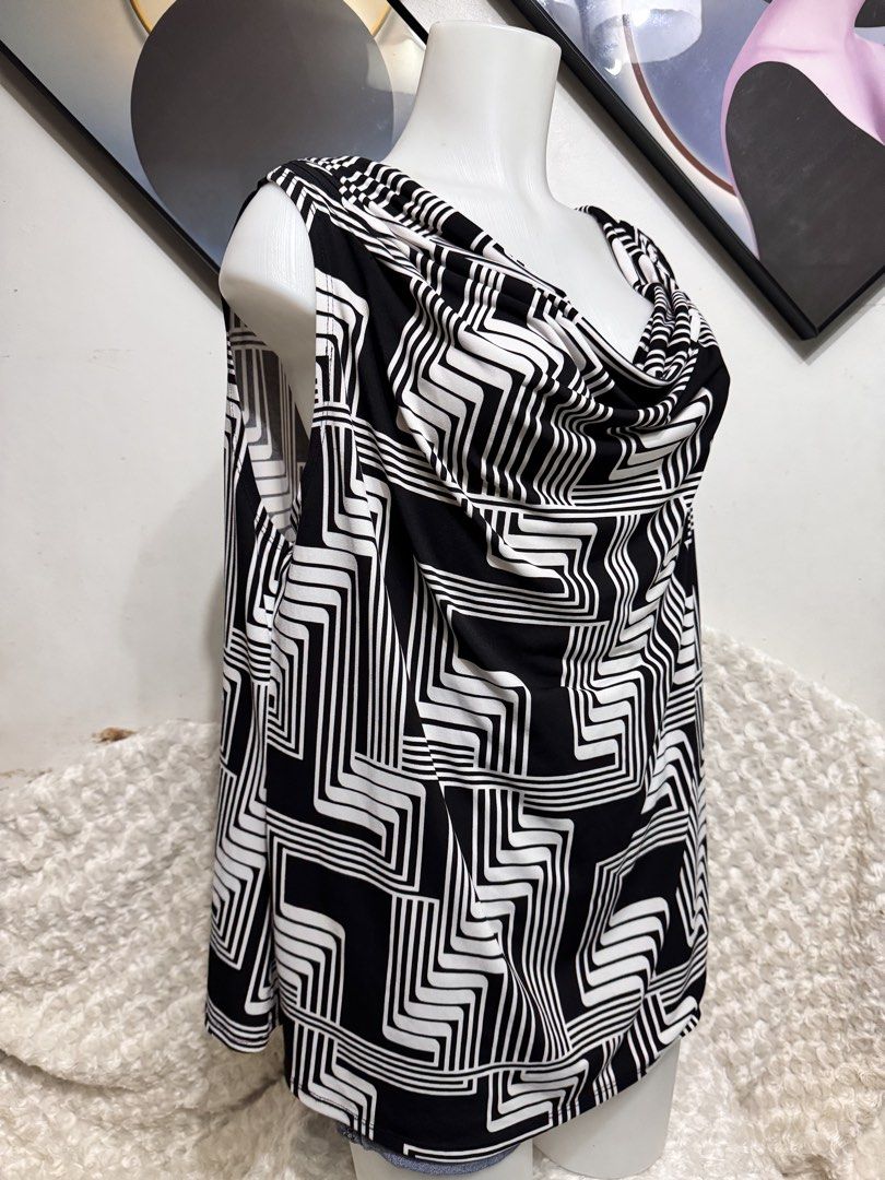 Sleeveless Cowl Neck Geometric Print Top (Category: Sleeveless) located in Marikina City. Submitted by lorradel (Listing ID 1459424973, Image 2). Description: - Sleeveless top in classic black and white. - Features a striking geometric print. - Elegant cowl neck design. - Versatile: dress up or down. - Comfortable and stylish. - Pairs perfectly with jeans or skirts. - MAY HAVE some washable stains (hindi maiiwasan) needs washing; had been stored 