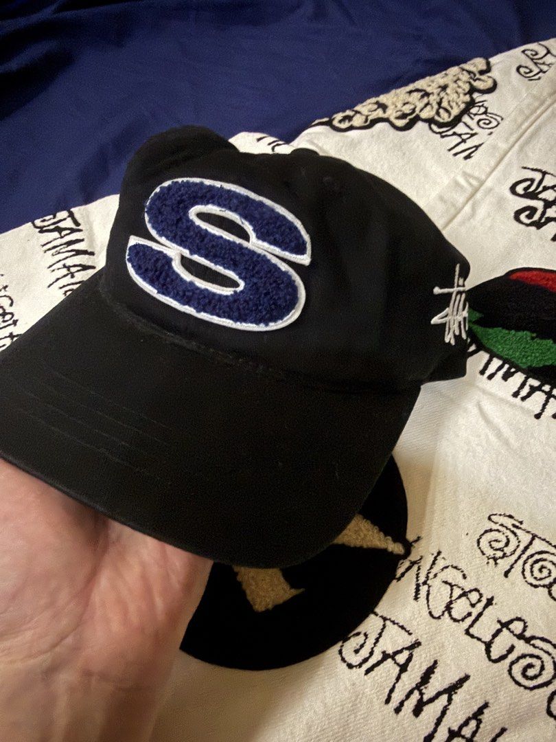 Stussy Black Cap with S Logo (Category: Caps & Hats) located in Manila. Submitted by 35thcollections (Listing ID 1459333649, Image 1). Description: - Classic black Stussy cap - Features a prominent blue 'S' logo on the front - Stussy logo embroidered on the back - Adjustable strap for a comfortable and secure fit - Ideal for everyday casual wear.