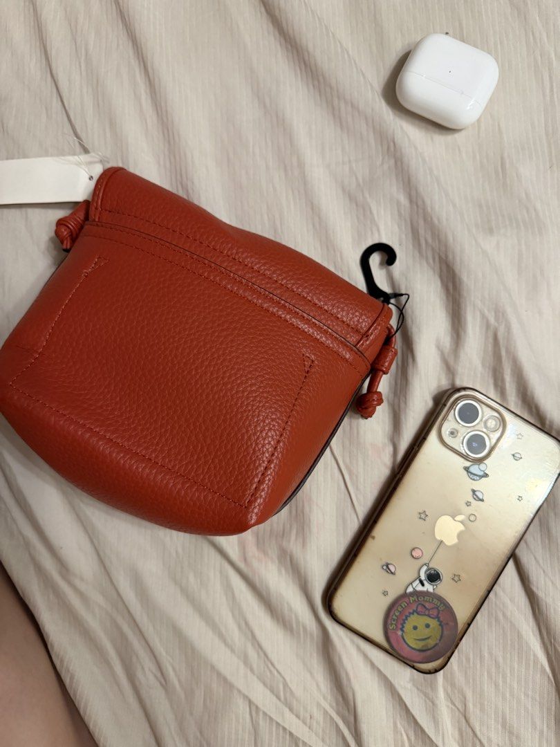 Uniqlo Gem Bag (Orange/Red) Small (Category: Cross-body Bags) located in Quezon City. Submitted by lizellescloset (Listing ID 1459471681, Image 3). Description: - Stylish orange/red tote bag - Durable canvas material - Spacious interior - Classic and versatile design - iphone 13 to scale size.