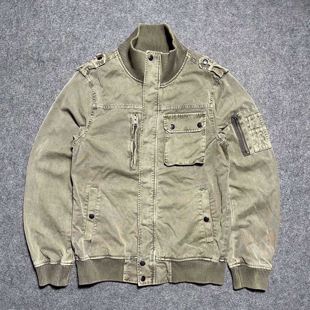 Vintage Corisco washed canvas military bomber jacket (Category: Coats, Jackets and Outerwear) located in Zamboanga. Submitted by rag_20 (Listing ID 1459462789, Image 1). Description: Vintage Corisco washed canvas military bomber jacket It features a rugged, utility-focused design made from a faded khaki-olive cotton canvas, stylized with prominent ribbed knit trimming at the mock neck collar, waist hem, and cuffs, Asymmetrical multi-pocket layout
