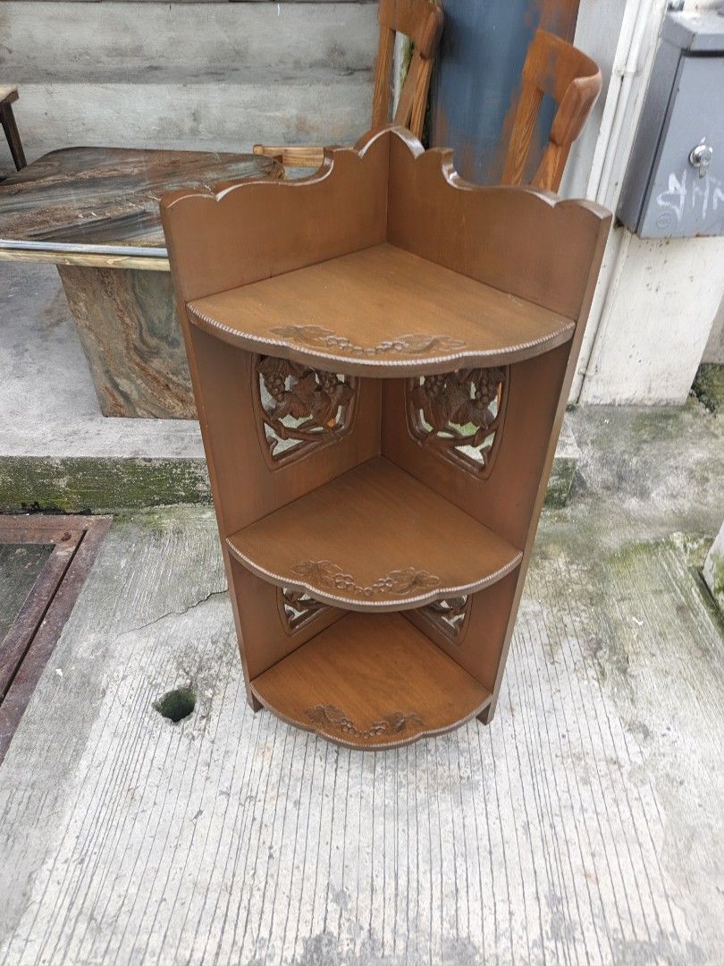 Wooden Corner Shelf with Carved Grape Design (Category: Shelves, Cabinets & Racks) located in Valenzuela. Submitted by kendra071914 (Listing ID 1459361843, Image 3). Description: - Three-tiered wooden corner shelf - Features intricate carved grape vine details on side panels - Perfect for plants, books, or decor - Space-saving design for any corner - Warm, brown wood finish - Shows minor scuffs from normal use.