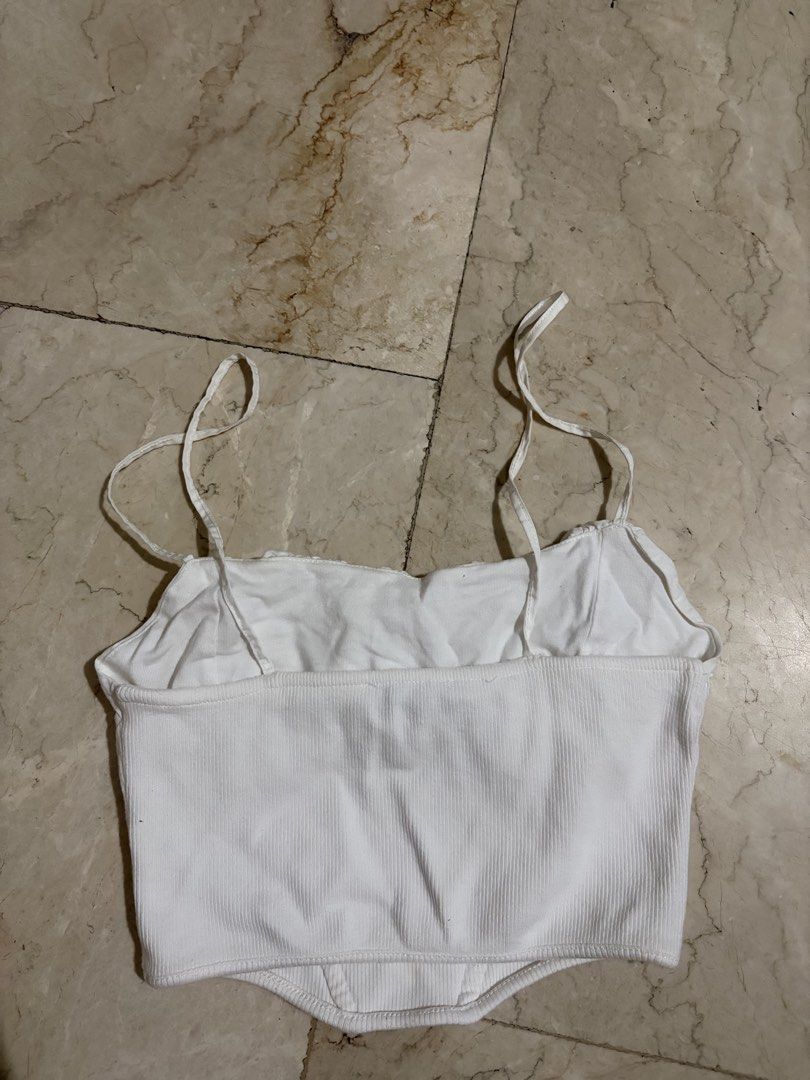 Zara White Ruched Corset Crop Top (Category: Sleeveless) located in Bacoor. Submitted by gailscollections (Listing ID 1459487113, Image 3). Description: Chic Zara white crop top featuring a gathered ruched neckline, delicate spaghetti straps, and a fitted corset-style silhouette. The ribbed stretch fabric and seam detailing create a flattering, feminine shape. Perfect for pairing with jeans, skirts, or tailored trousers for an effortless everyday