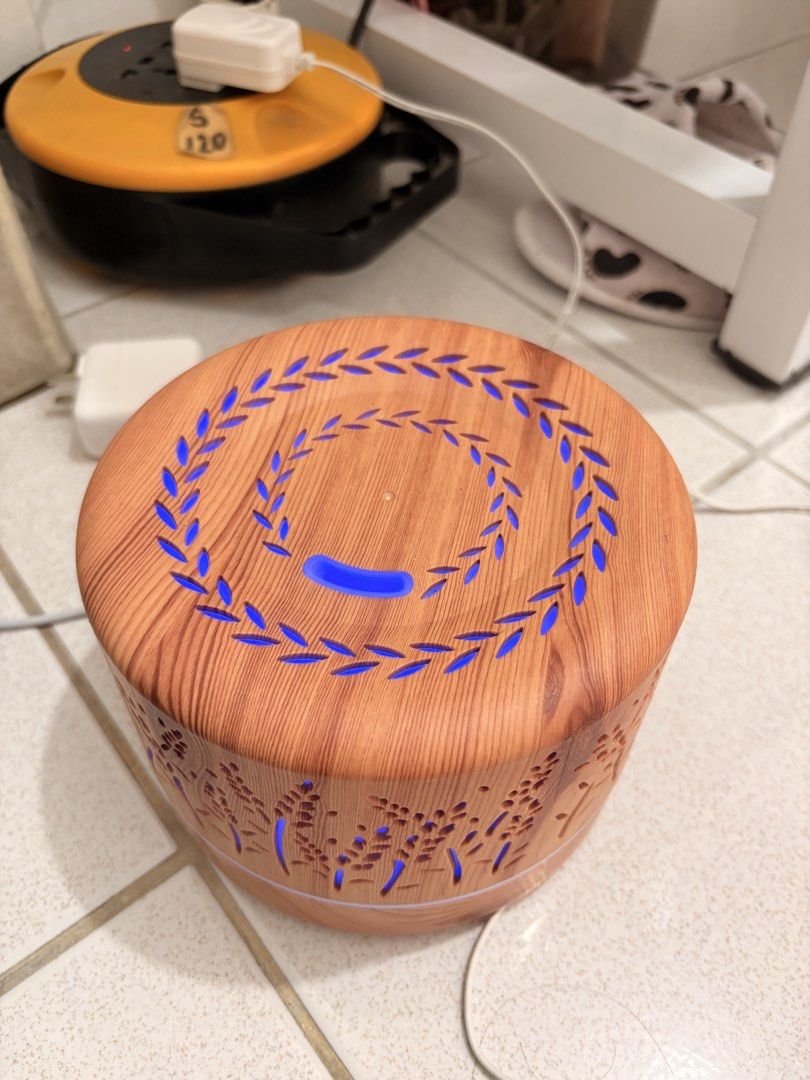ZenScent Aroma Diffuser with Wood Grain Finish & LED Light (Category: Home Fragrance) located in Pasig City. Submitted by hey_declutter (Listing ID 1459354032, Image 1). Description: - Wooden-look aroma diffuser - Features soothing blue LED light - Comes with a small bottle of 'Rose Petals Orange & Musk' essential oil - Lightly used, excellent working condition - Creates a relaxing atmosphere in any room.