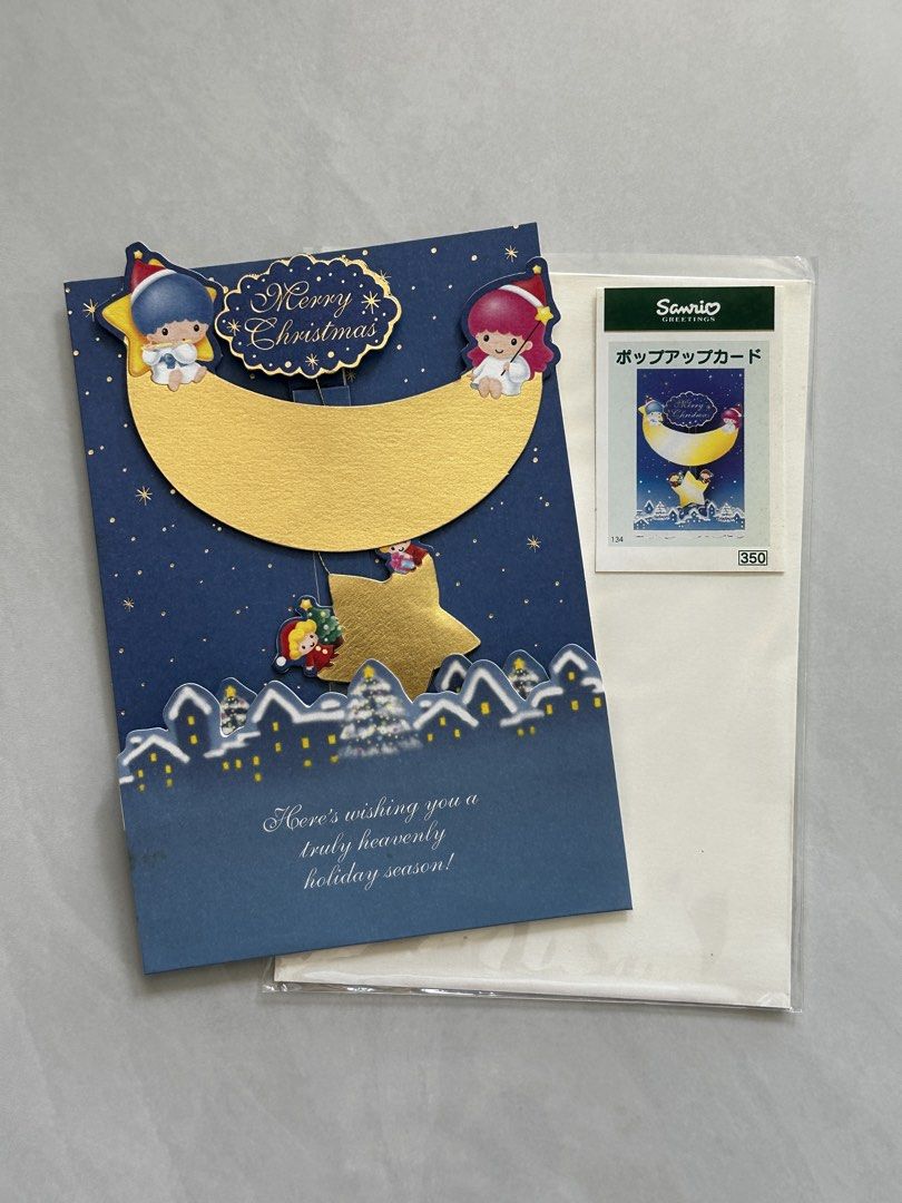 1999年 Sanrio Little Twin Stars 立體聖誕卡 Christmas Pop-Up Card （分類：動漫角色周邊）位於 Hong Kong。 由 tinydings 提交（商品編號 1465034885，圖片 1）。簡介： Sanrio Little Twin Stars Christmas pop-up greeting card from 1999. Blue night sky design with a gold moon, hanging star, and snowy village below. Unused item complete with original protective plastic sleeve and white envelope. Licensed Sanrio item with barcode and copyright text on the back.。