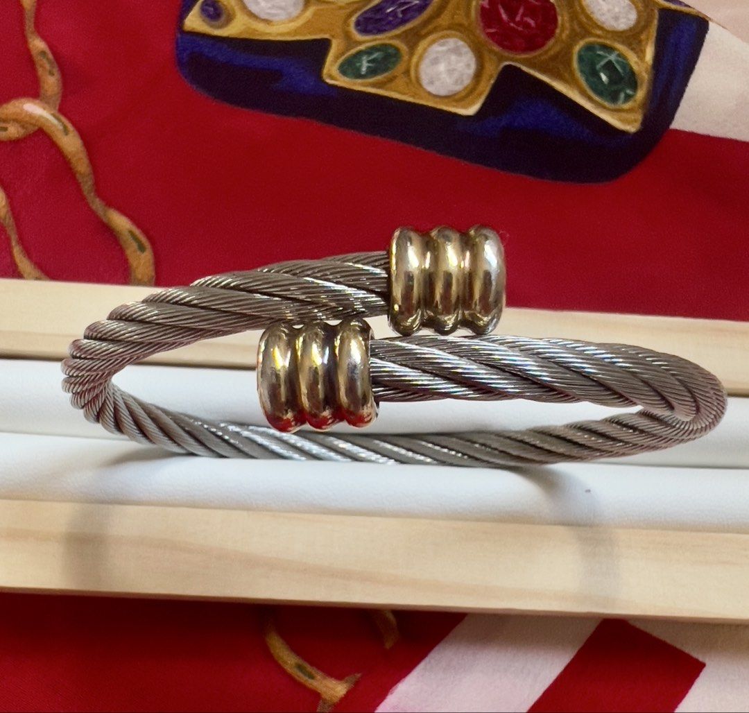 💝 Charriol Cable Bangle (Category: Bracelets) located in Manila. Submitted by penchantforprettythings (Listing ID 1464978637, Image 1). Description: Cable Integrity: The twisted stainless steel cable structure looks intact and tight, showing no signs of severe kinking, loose fraying wires, or misshapen over-stretching. Metal Plating & Finish: The silver-toned steel retains a good luster. The gold-plated decorative end clips show some light surfa