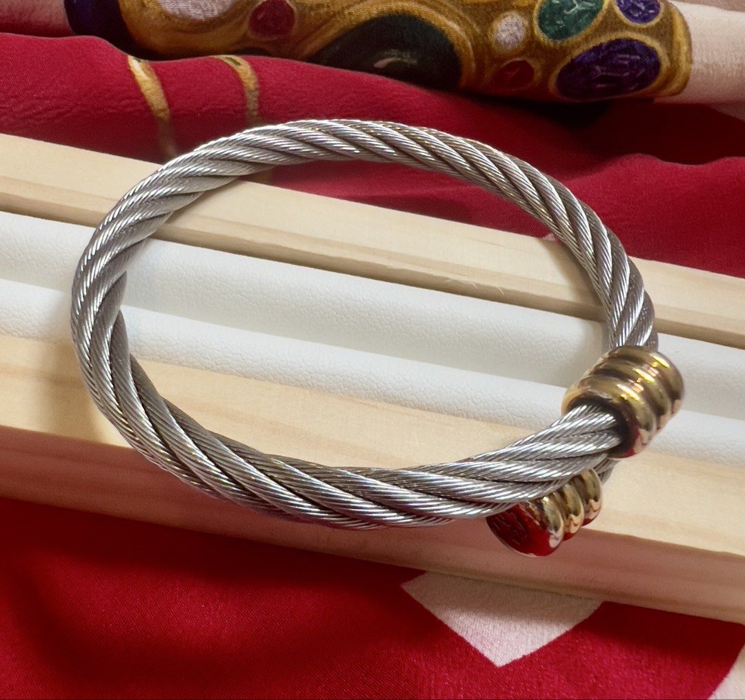 💝 Charriol Cable Bangle (Category: Bracelets) located in Manila. Submitted by penchantforprettythings (Listing ID 1464978637, Image 2). Description: Cable Integrity: The twisted stainless steel cable structure looks intact and tight, showing no signs of severe kinking, loose fraying wires, or misshapen over-stretching. Metal Plating & Finish: The silver-toned steel retains a good luster. The gold-plated decorative end clips show some light surfa
