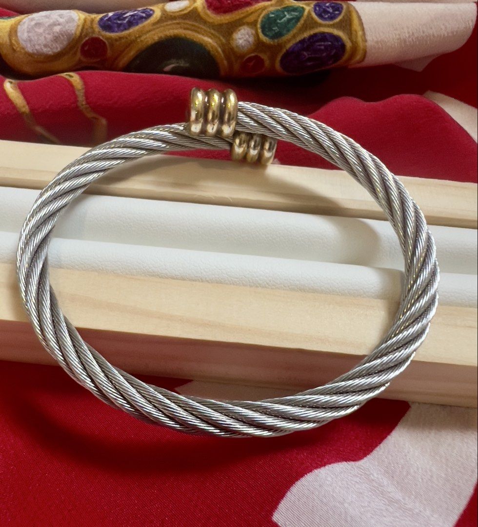 💝 Charriol Cable Bangle (Category: Bracelets) located in Manila. Submitted by penchantforprettythings (Listing ID 1464978637, Image 3). Description: Cable Integrity: The twisted stainless steel cable structure looks intact and tight, showing no signs of severe kinking, loose fraying wires, or misshapen over-stretching. Metal Plating & Finish: The silver-toned steel retains a good luster. The gold-plated decorative end clips show some light surfa