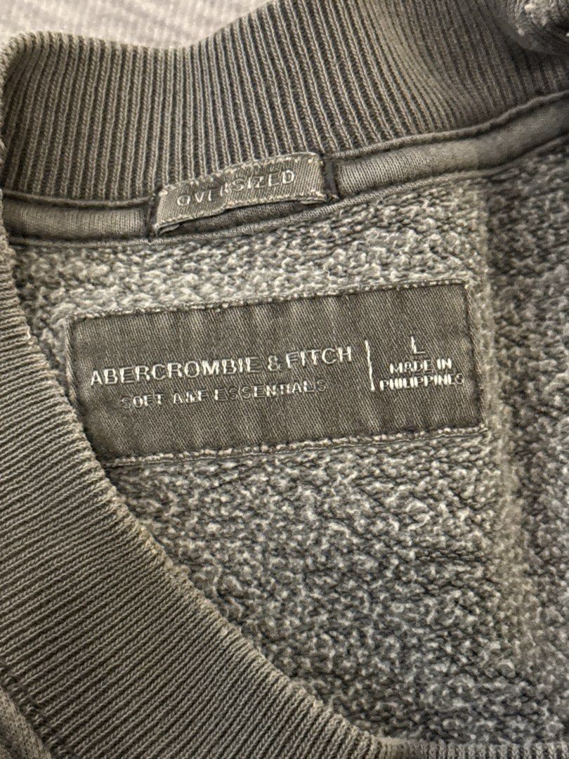 Abercrombie & Fitch Oversized Soft AF Essentials Sweatshirt (Category: Hoodies) located in Calamba. Submitted by leeadriannn796 (Listing ID 1464975732, Image 2). Description: - Brand: Abercrombie & Fitch - Style: Oversized crewneck sweatshirt with v-stitch collar - Color: Dark grey wash - Size: Large - Interior: Super soft fleece lining - Details: Ribbed cuffs and hem - Origin: Made in the Philippines.