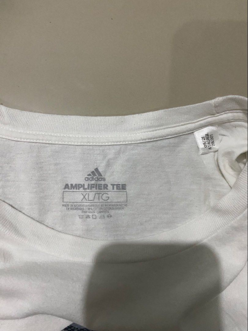 Adidas Amplifier Tee White Camo Logo (Category: Tshirts & Polo Shirts ) located in Makati City. Submitted by dymon_08 (Listing ID 1465105030, Image 3). Description: - Brand: Adidas - Dines W 17.5 L22.5 - Style: Amplifier Tee (Classic crew neck, short sleeves) - Color: White with large camouflage chest logo - Size: XL - Material: 100% cotton (Made in Nicaragua) - Condition: Clean fabric with regular wear, good for everyday casual use.