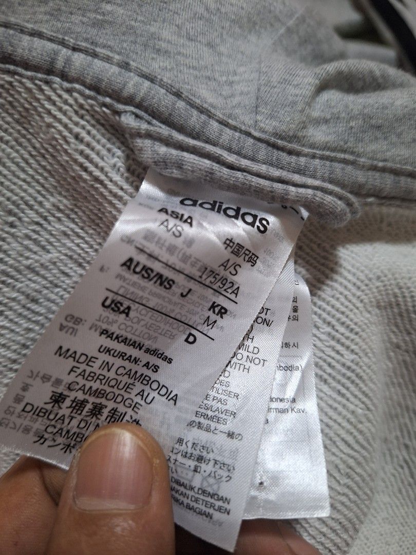 Adidas Grey Zip-Up Hoodie (Category: Hoodies) located in Mabalacat. Submitted by jhaycore05 (Listing ID 1465097558, Image 2). Description: - Brand: Adidas - Color: Grey with black signature stripes and drawstrings - Size: (USA S/M) 20x27.5 - Material: Comfortable cotton - Features: Full zip-up, front kangaroo pockets, and small printed chest wordmark logo - Condition: Excellent no issue.