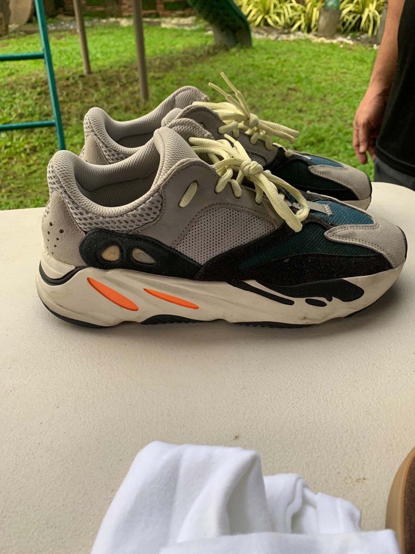 Adidas Yeezy Boost 700 Wave Runner (Category: Sneakers) located in Mandaluyong City. Submitted by antownr (Listing ID 1465066841, Image 1). Description: - Brand/Model: Adidas Yeezy Boost 700 Wave Runner - Colorway: Grey, black, and teal mesh and suede upper with bright orange midsole accents - Sole: Black rubber outsole with visible Boost cushioning and pale yellow laces - Condition: Regular wear on soles and midsoles, with light dirt marks throu