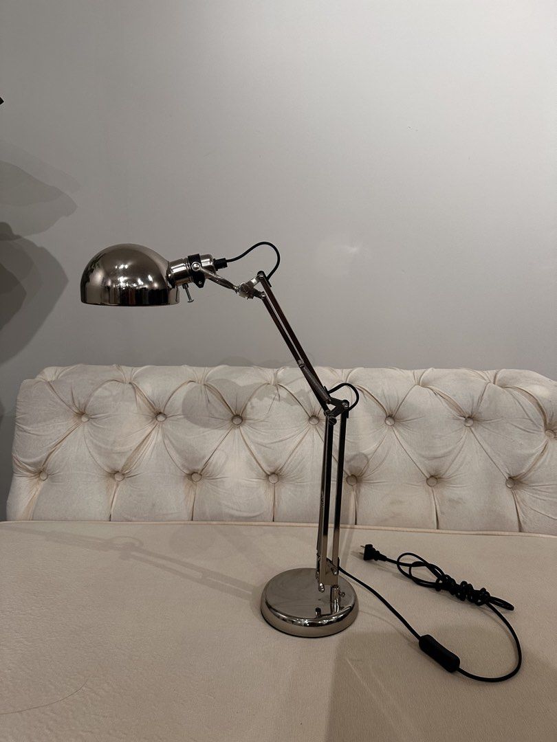 Adjustable Metal Desk Lamp Silver from IKEA (Category: Lighting) located in Manila. Submitted by thriftyfindshub (Listing ID 1465061551, Image 1). Description: - Adjustable multi-joint arm to direct light easily - Sleek polished silver finish with a clean industrial look - Round weighted base for maximum stability - Standard plug-in cord with convenient inline rocker switch - Perfect for study desks, work from home setups, and bedside tables.