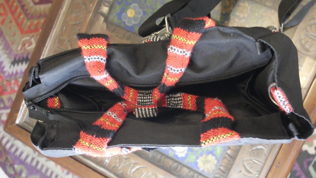 Akbay convertible black backpack with patterned straps (Category: Backpacks) located in Taguig. Submitted by spaula76 (Listing ID 1465003527, Image 2). Description: - Brand: AKBAY Habi multi way bag - Material: Durable black canvas with vibrant woven strap accents (red, orange, black) - Versatile Design: Multi-way wear with adjustable shoulder straps and top handles - ​3-way style (tote,shoulder,back pack) ​- Interior and Water Resistant ​-padded
