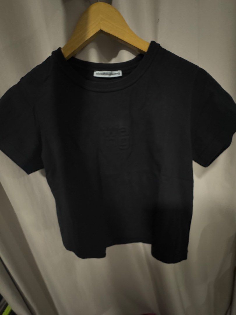 Alexander Wang Black Crop Top with Embossed Logo (Category: Shirts) located in Manila. Submitted by decluterthings888 (Listing ID 1465109188, Image 2). Description: - Brand: Alexander Wang - Color: Black - Style: Short-sleeve crop top with crew neck - Detail: Embossed 'wang' lettering on the front chest - Material: Soft, high-quality cotton with clean stitching - Fit: True to size, great for pairing with high-waisted jeans or shorts.