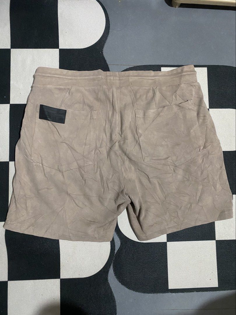 Alphalete Tan Drawstring Athletic Shorts (Category: Shorts) located in Las Pinas. Submitted by matilliano76499 (Listing ID 1465085508, Image 3). Description: - Brand: Alphalete - Color: Tan - Material: 95% Cotton, 5% Elastane - Waist: ~15" flat across (adjustable elastic drawstring) - Length: ~18.5" - Pockets: Two secure zippered side pockets + rear patch pockets - Details: Black rubber brand patches on lower leg and back pocket - Condition: Exce