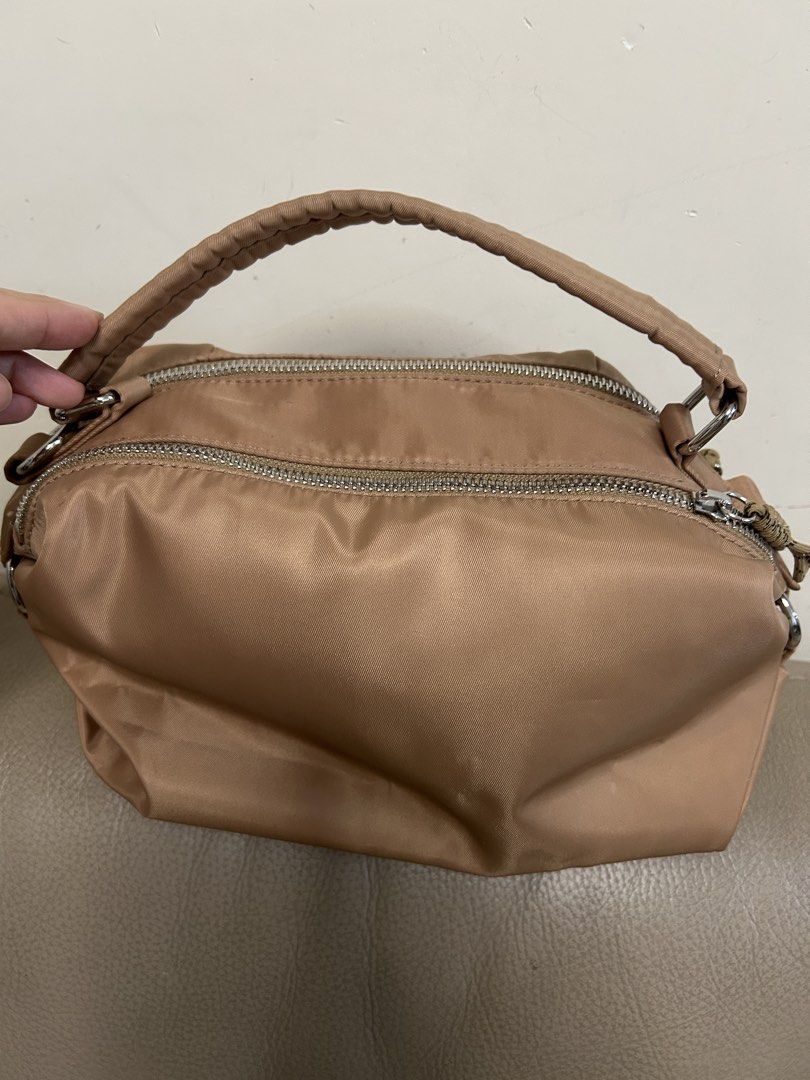 Ameri NYLON BAG （分類：單肩包）位於 Hong Kong。 由 jwhc0317 提交（商品編號 1464990599，圖片 6）。簡介： Ameri Vintage 尼龍手袋，奶茶色身配埋深藍色皺褶挽帶，造型好特別。可以側揹又可以手拎，望落去好有層次感。間隔實用，平時出街返工都好襯衫。。