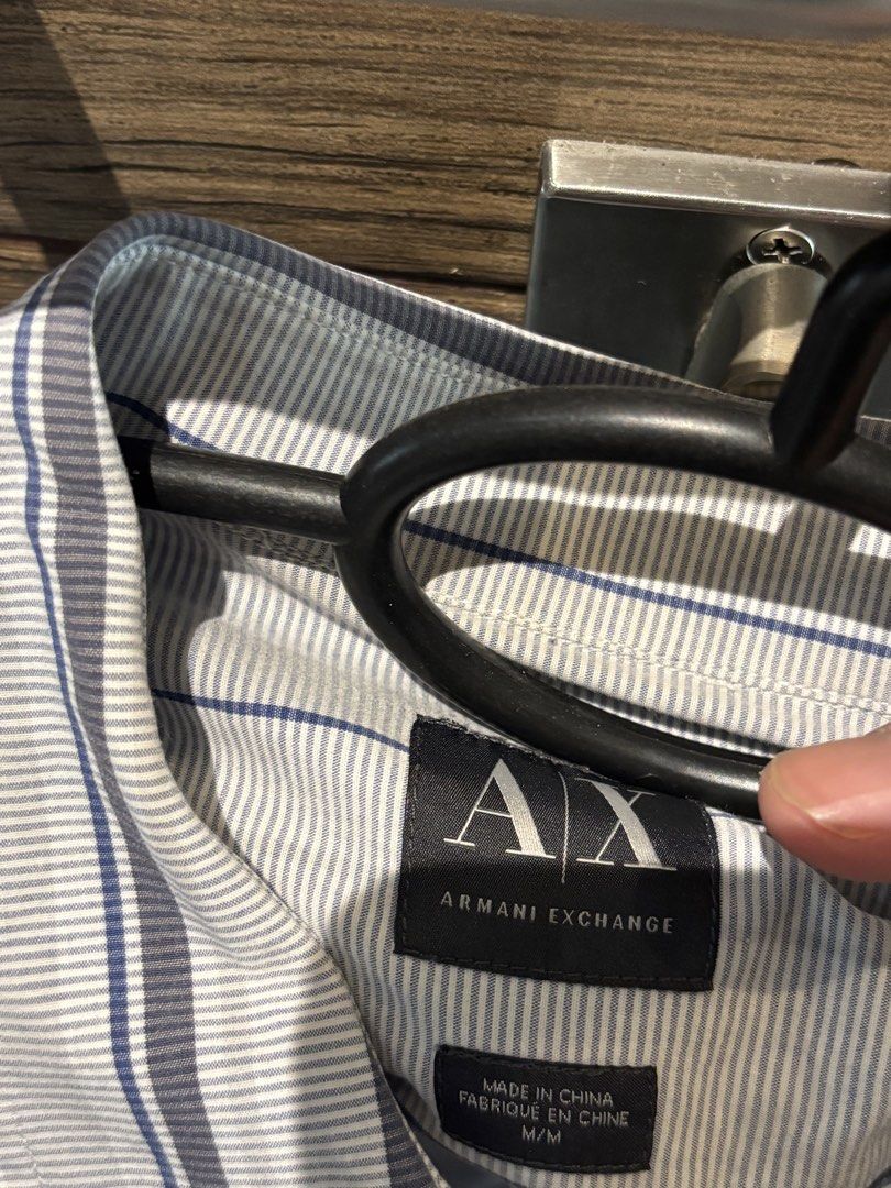 Armani Exchange Striped Long Sleeve Button-Down Shirt Size M (Category: Tshirts & Polo Shirts ) located in Quezon City. Submitted by tanmiguel1998 (Listing ID 1465005169, Image 2). Description: - Brand: Armani Exchange - Design: Blue and white pinstripe pattern with vertical stripe accents - Details: Classic collar, front button closure, long sleeves with button cuffs - Size: Medium (M) - Origin: Made in China - Condition: Clean fabric, excellent