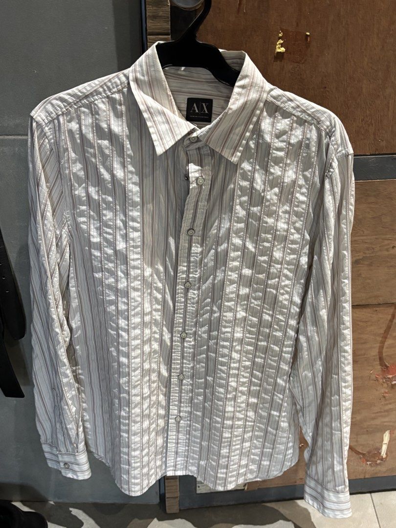 Armani Exchange Striped Long Sleeve Button-Down Shirt - US Medium (Category: Tshirts & Polo Shirts ) located in Quezon City. Submitted by tanmiguel1998 (Listing ID 1465058167, Image 1). Description: - Brand: Armani Exchange - Style: Long sleeve button-down shirt with standard collar - Pattern: Vertical brown and light blue stripes on a white base - Size: Medium - Material: Lightweight with a subtle textured crinkle pattern - Origin: Made in India