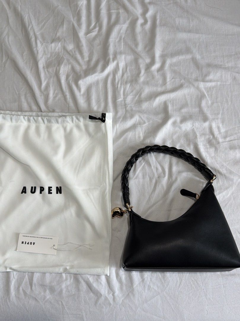 Aupen Black Leather Shoulder Bag with Braided Handle (Category: Shoulder Bags) located in Quezon. Submitted by gabriel_borres (Listing ID 1464993564, Image 2). Description: - Brand new/Pristine condition black Aupen shoulder bag - Crafted from smooth leather with a structured rectangular base - Unique braided handle accented with a cute gold-tone heart charm - Secure top zipper closure for daily essentials - Comes complete with original white dus
