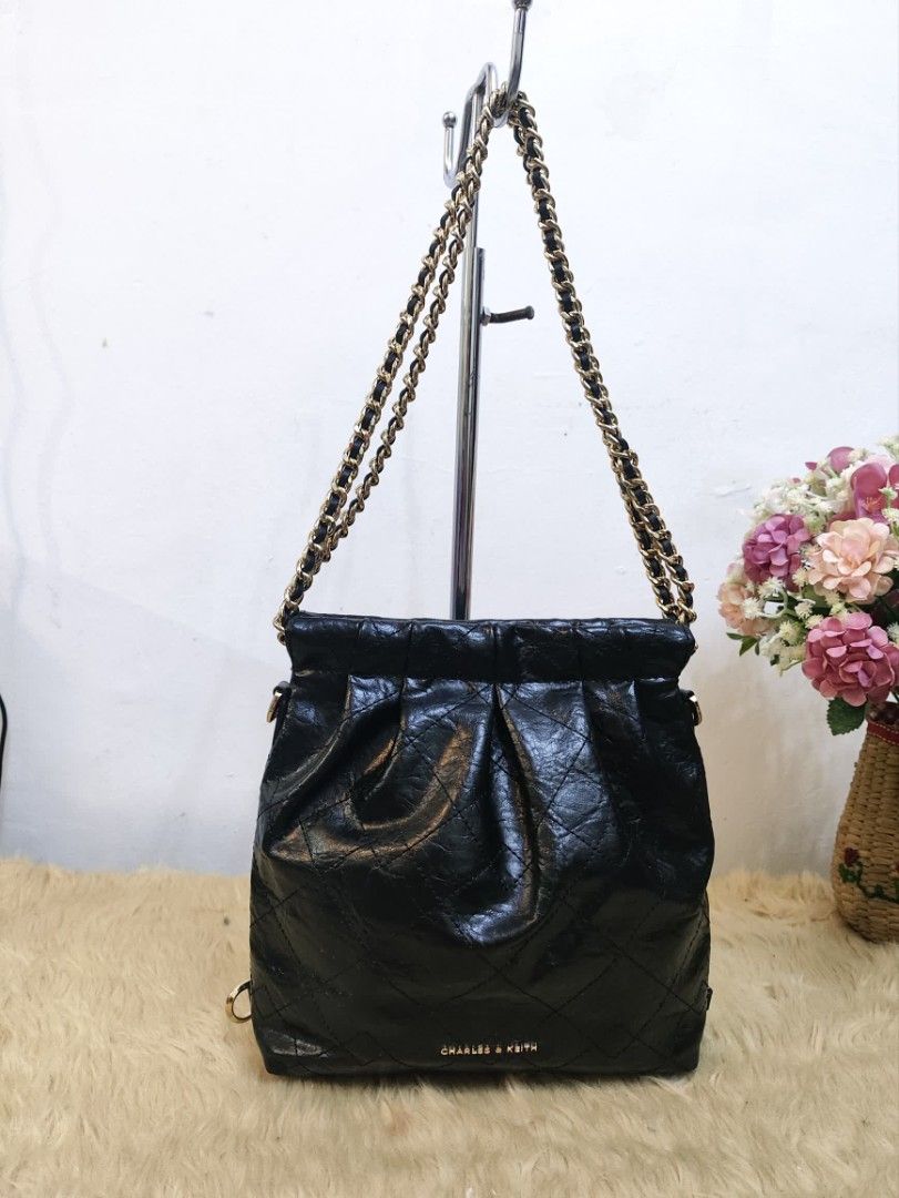 Authentic Charles & Keith duo chain shoulder bag (Category: Shoulder Bags) located in Rizal. Submitted by hsiri1128 (Listing ID 1465085099, Image 1). Description: 💯✔️Legit CONDITION : 9/10 ISSUE / FLAWS : Missing ung long chain nya para maging back pack xa and sling. MATERIAL : Faux Leather w/ gold hardwares DETAILS : Fit notebook and long wallet. very black in actual, no visible rubs/bakbak. magnetic closure.