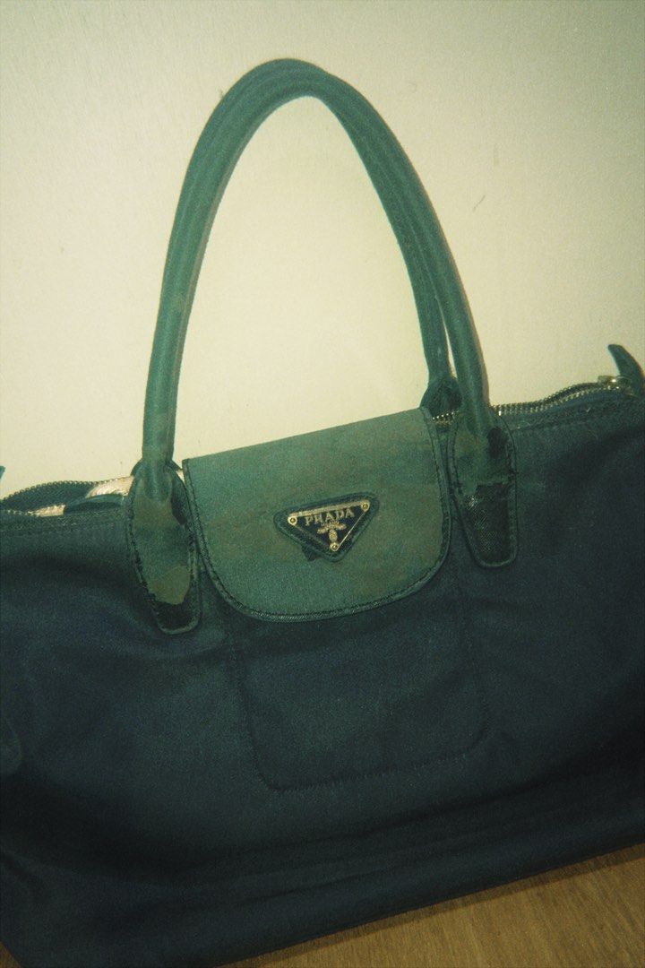 Authentic Prada (Category: Luxury Bags & Wallets) located in Batangas. Submitted by cllavz (Listing ID 1464991780, Image 1). Description: Authentic Prada Nylon Bag – Features the iconic metal triangle logo. Note: Has peeling and flaking on the leather flap cover and handles due to long-term storage; needs minor repair or TLC..