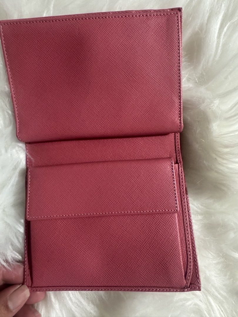 Authentic Prada Pink Saffiano Leather Wallet (Category: Luxury Bags & Wallets) located in Quezon City. Submitted by jbspreloved (Listing ID 1465074387, Image 3). Description: - Brand: Prada - Material: Durable Saffiano leather in a vibrant pink shade - Design: Classic triangular enamel logo plaque and front flap snap closure - Interior: Multiple compartments including a dedicated coin pocket with a flap - Size: Compact and lightweight, designed t