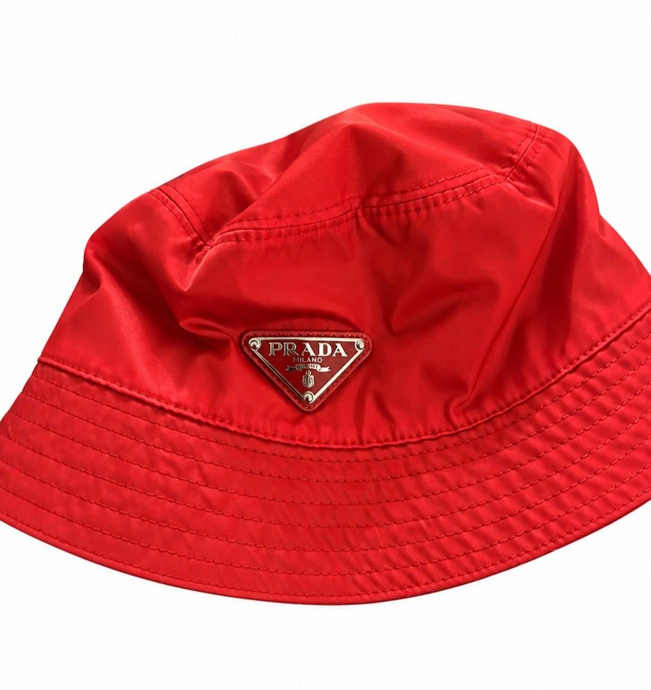 Authentic Prada Re-Nylon Bucket Hat in Red (Category: Caps & Hats) located in Makati City. Submitted by trevarucci (Listing ID 1465122756, Image 3). Description: - SIZE L (57CM TO 59CM) 22.5" TO 23" - Orig. Price : P48,000 - comes with original box - Brand: Prada - Item: Re-Nylon Bucket Hat - Color: Bright Red - Condition: Brand new, unworn with tags attached - Details: Iconic enameled metal triangle logo, classic stitched brim - Style: Great sta