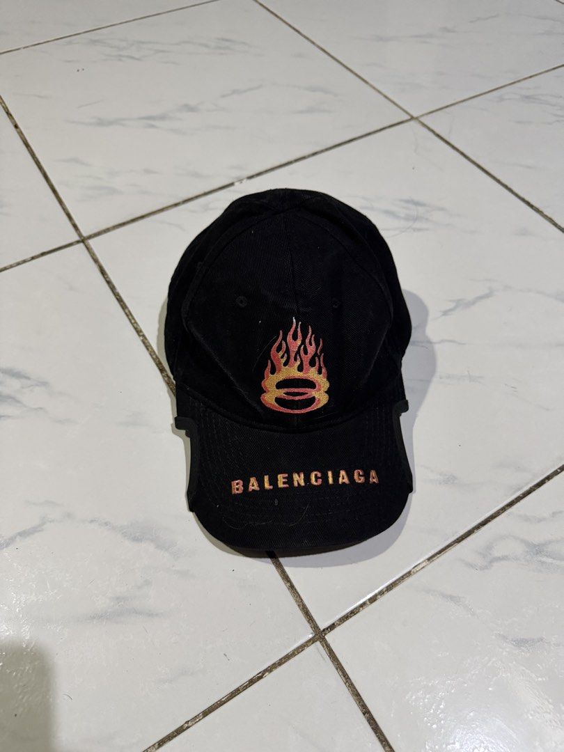 Balenciaga Flame Embroidery Baseball Cap Black (Category: Caps & Hats) located in Manila. Submitted by swag_shop00 (Listing ID 1465102530, Image 1). Description: - Brand: Balenciaga - Color: Black - Material: 100% Cotton (Made in Italy) - Design: Flame embroidery on front and back panels - Details: Balenciaga logo embroidered on the curved brim - Fit: Adjustable strap at the back - Condition: Clean interior lining with proper brand tags attached.