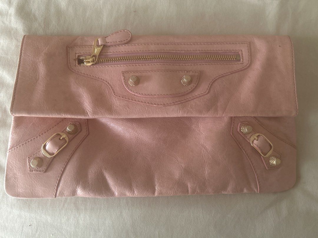 Balenciaga Pink Leather Envelope Clutch (Category: Luxury Bags & Wallets) located in Manila. Submitted by eeerk (Listing ID 1464970406, Image 1). Description: - Brand: Balenciaga - Style: Envelope clutch in soft pink leather - Hardware: Gold-toned with signature stud and buckle details - Closure: Fold-over flap with magnetic snap - Pockets: Convenient front zip pocket - Interior: Dark lining with Balenciaga Paris leather brand patch - Capacity: S