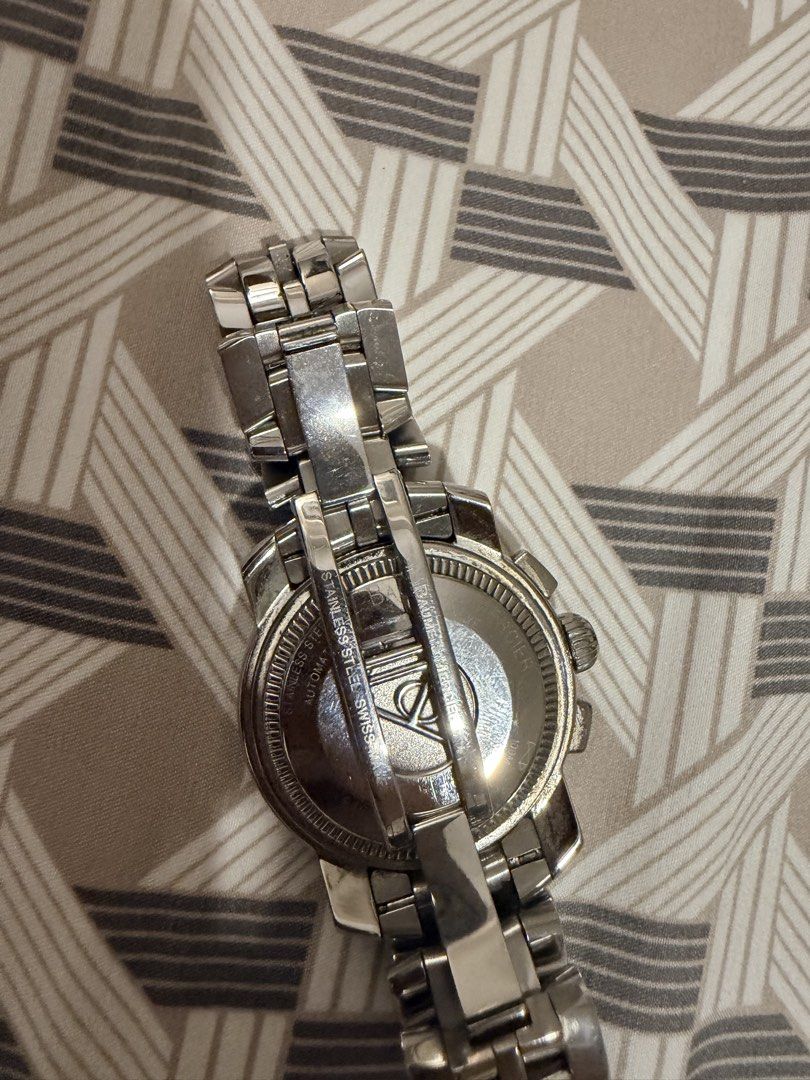 Baume & Mercier Geneva Automatic Chronograph Watch (Category: Luxury Watches) located in Manila. Submitted by jack81472 (Listing ID 1465081131, Image 2). Description: - Brand: Baume & Mercier Swiss-Made Automatic Chronograph Watch - Material: Stainless steel case and link bracelet with butterfly clasp - Dial: White dial featuring Arabic numerals, a date window at 3 o'clock, and multiple sub-dials - Case Back: Steel back engraved with official bra