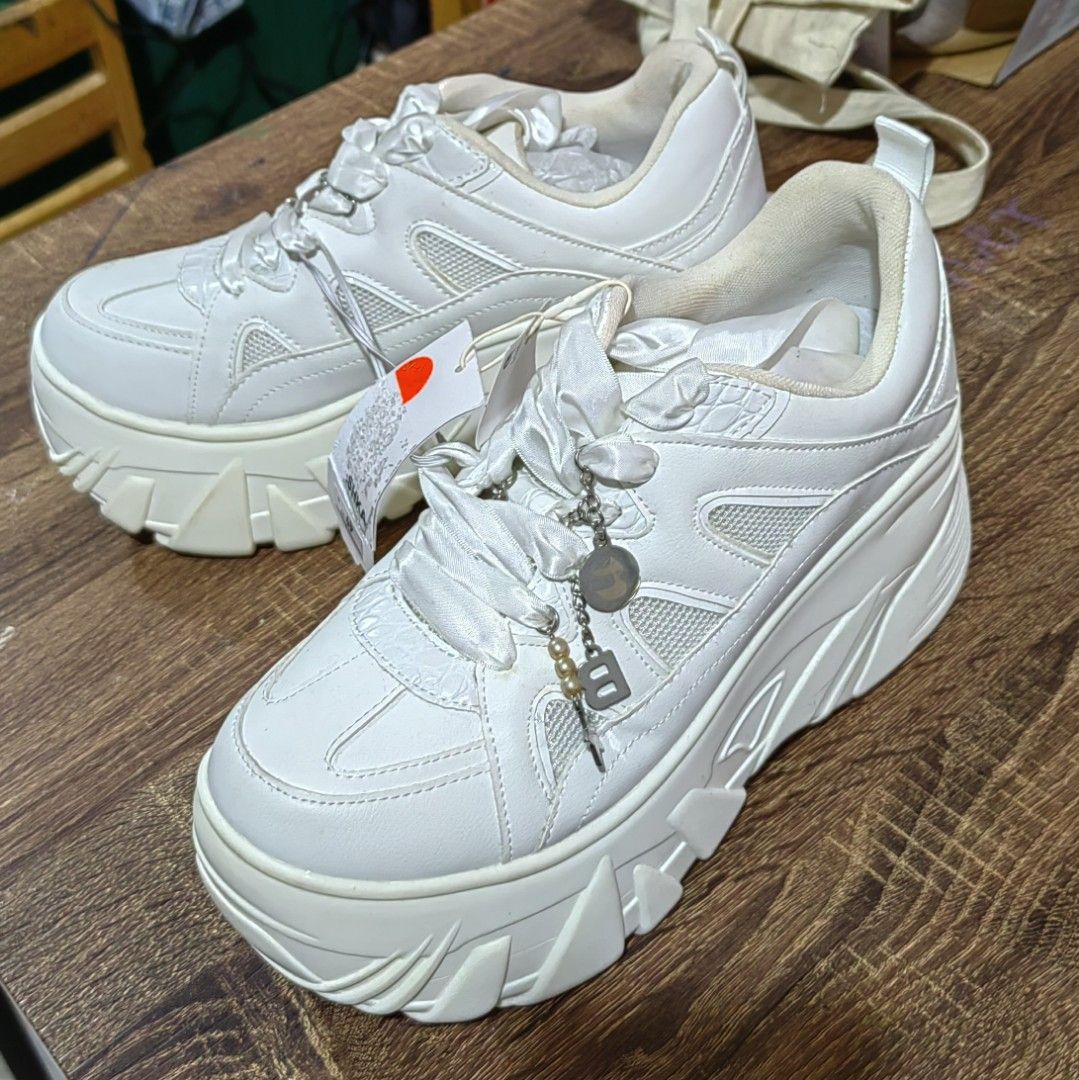 Bershka Chunky White Platform Sneakers Size 41 (Category: Sneakers) located in Muntinlupa City. Submitted by jaz_things (Listing ID 1465169846, Image 3). Description: - Brand new with original store tags - Trendy all-white colorway with a thick platform sole and chunky tread pattern - Features unique wide ribbon laces - Comes with an attached charm chain detail featuring pearls and a letter pending - unused .