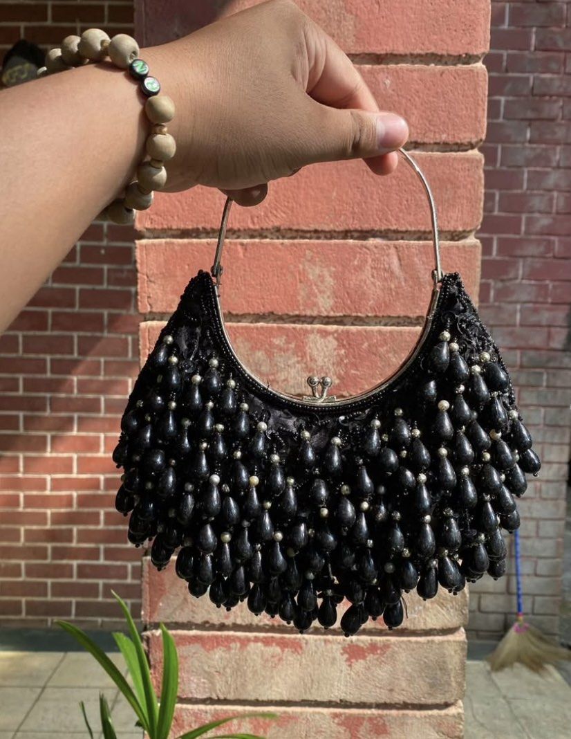 Black Beaded Crescent Evening Handbag (Category: Purses & Pouches) located in Caloocan City. Submitted by cleverwater.ba6482 (Listing ID 1465080575, Image 1). Description: - Color: Elegant black with shimmering beadwork - Design: Crescent shape covered in tiny seed beads and dangling teardrop beads - Closure: Secure metal frame with kiss-lock mechanism - Hardware: Silver top handle - Interior: Clean fabric lining, perfectly sized for small essent